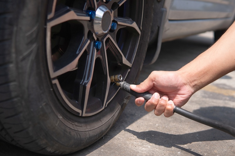 inflating-car-tire-with-air-hose-on-street-2026-03-24-06-22-40-utc.jpg
