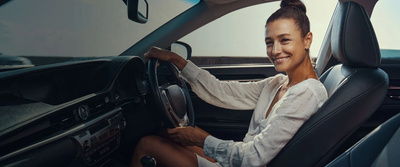Happy driver sat behind the wheel of their new car 