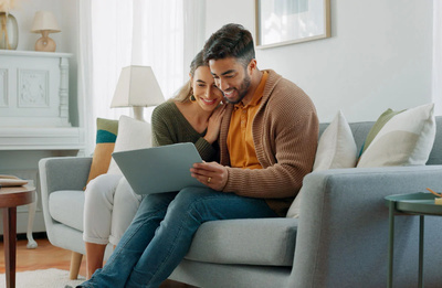 Man and woman sat on sofa with laptop