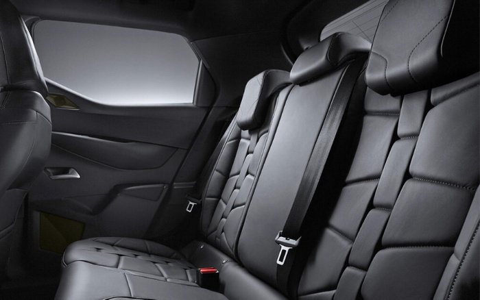Interior view of a car's back seat featuring black leather upholstery with a modern, quilted design. The image shows three headrests and a seatbelt, highlighting the spacious and luxurious seating area typical of new cars. This interior detail is relevant for those interested in used cars and new cars with premium features.
