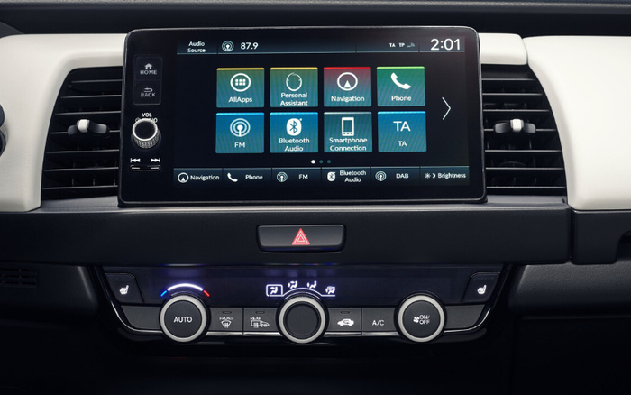 Car dashboard featuring a touchscreen multimedia display showing options such as AllApps, Personal Assistant, Navigation, Phone, FM, Bluetooth Audio, Smartphone Connection, and TA. The screen also displays radio frequency 87.9 and time 2:01. Below the screen are climate control knobs including AUTO, front and rear defrost, air conditioning, and seat heating buttons. This modern car interior is suitable for both used cars and new cars buyers seeking advanced tech features.