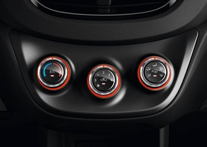 Close-up of car dashboard climate control knobs showing settings for A/C, fan speed 0 to 4, and air circulation modes including front and rear defrost. The control rings are illuminated with red light. Suitable for used cars and new cars interior features.