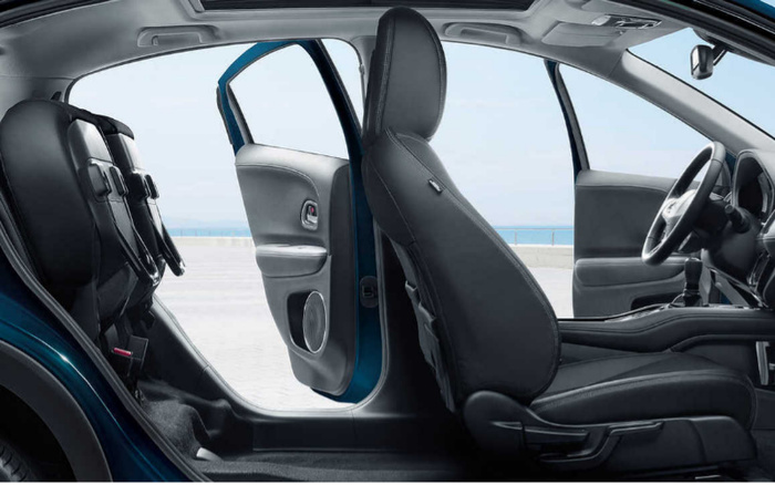 Interior view of a modern car with both front and rear passenger doors open, showcasing black leather seats, spacious legroom, and a panoramic sunroof, ideal for customers browsing used cars and new cars.