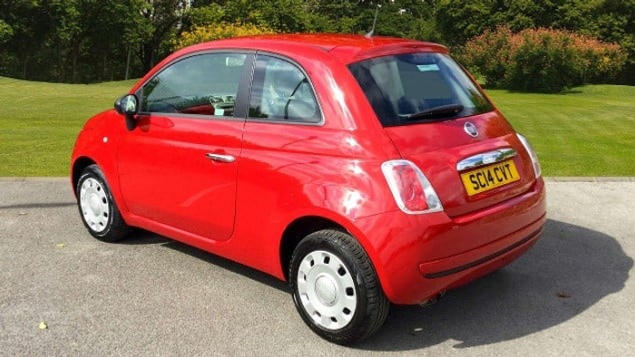 Red Fiat 500 parked on a driveway with green grass and trees in the background, displaying a UK registration plate SC14 CVT, suitable as an example of used cars or new cars available for sale.