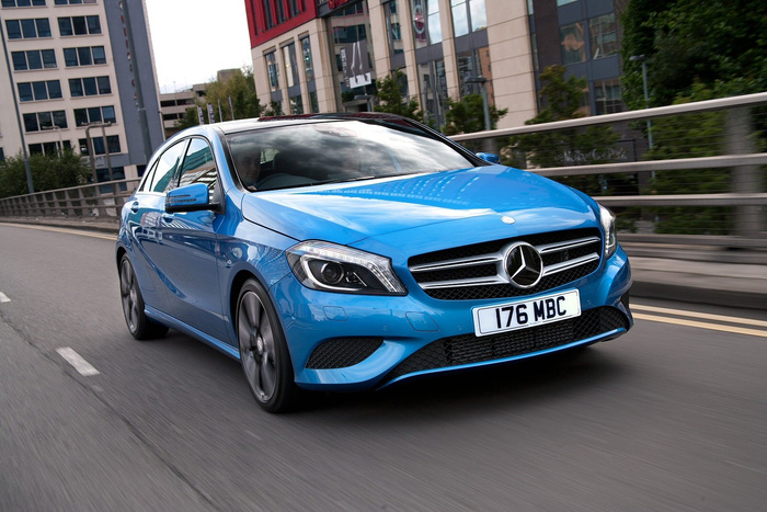 Blue Mercedes-Benz car with license plate 176 MBC driving on a city road with buildings and greenery in the background, representing new cars and used cars.