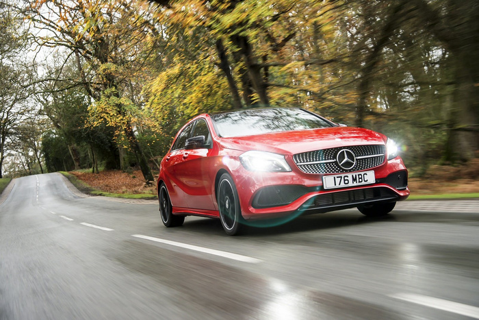 Red Mercedes-Benz car with registration plate 176 MBC driving on a wet road surrounded by autumn trees, representing a high-quality vehicle suitable for buyers interested in both used cars and new cars.