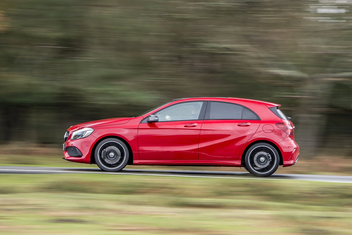Red Mercedes-Benz A-Class hatchback driving fast on a road with blurred green trees in the background, showcasing a sleek and sporty design suitable for buyers interested in used cars and new cars.
