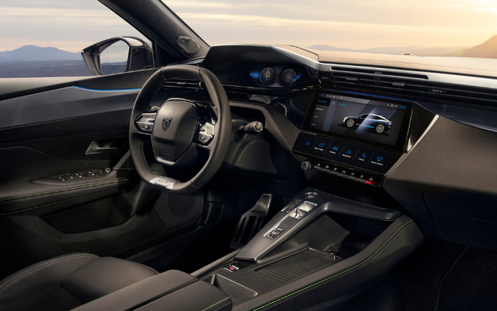 Interior dashboard of a Peugeot car showing the steering wheel with Peugeot logo, digital instrument cluster, and a central touchscreen displaying a car profile and menu options including Media, Nav, Apps, Car, and Phone. The modern cockpit features black upholstery with green stitching, sleek door controls, and a scenic view of mountains and water outside. Suitable for advertising used cars and new cars.