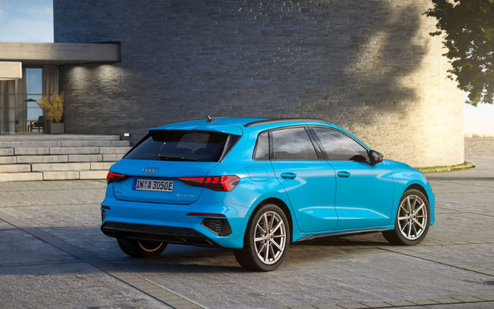 Bright blue Audi A3 Sportback 40 TFSI e plug-in hybrid car parked outside a modern building, viewed from the rear-side angle with license plate IN A 3050E visible, showcasing a sleek design ideal for used cars and new cars buyers.