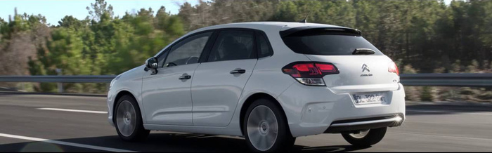 White Citroën hatchback car driving on a highway with trees in the background, showcasing a clean and modern design, suitable for buyers interested in used cars or new cars.
