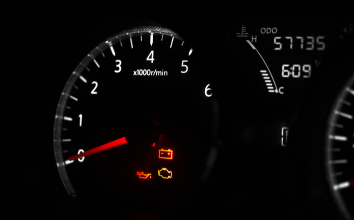 Close-up of a car driver's display showing oil, engine, and battery warning lights