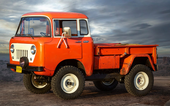 Vintage orange and white Ford 4x4 truck parked on a dirt surface under a cloudy sky, featuring rugged off-road tyres and a yellow license plate with the number 295-589, representing a classic vehicle ideal for used cars and new cars enthusiasts.