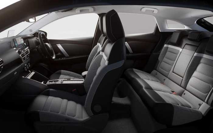 Interior view of a modern car showcasing front and back seats with dark fabric upholstery, a digital dashboard display, steering wheel, and centre console controls, highlighting the spacious and comfortable design suitable for both used cars and new cars.