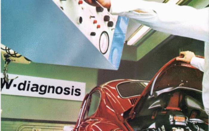 Technician in white coat using diagnostic equipment to inspect a red Volkswagen Beetle's engine at a diagnostic centre with a sign partially reading 'w.diagnosis', illustrating used cars inspection and maintenance; emphasises thorough checks for both used cars and new cars.