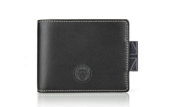 Black leather wallet with white stitching, featuring an embossed Jaguar logo and a stitched fabric pull tab with the Union Jack design, placed on a white reflective surface, suitable for promotional gifts in the used cars and new cars market.