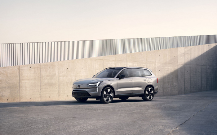 Silver modern electric SUV parked in an empty concrete industrial area with smooth walls under natural daylight, representing a new car model, suitable for adverts related to used cars and new cars.