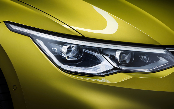 Close-up of a modern car headlight with 'IQ.LIGHT' branding on a shiny lime green vehicle, showcasing sleek and advanced lighting technology, suitable for advertising used cars and new cars.