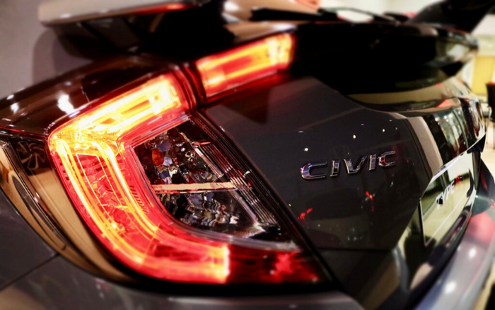 Close-up of the rear light and badge of a black Honda Civic Type R car, showcasing the distinctive tail light design and the Civic and Type R logos on the back. Ideal image for showcasing details of new cars and used cars.