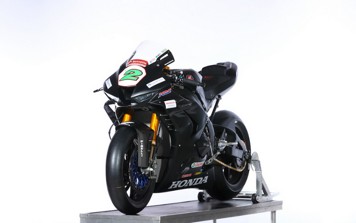 Black Honda racing motorcycle with the number 2 on the front, displayed on a metal stand against a white background. The bike features gold front forks, blue rims, and stickers including Bennetts, Pirelli, Castrol, and HRC, highlighting high-performance parts. This image relates to used cars and new cars as part of a broader range of vehicles for motorsport enthusiasts.