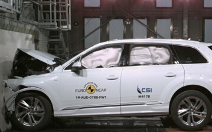 White SUV undergoing a crash test with front-end damage, side airbags deployed inside, marked with Euro NCAP logo and text '19-AUD-0788-FW1', alongside CSI logo with code M4178, illustrating safety testing relevant to used cars and new cars.