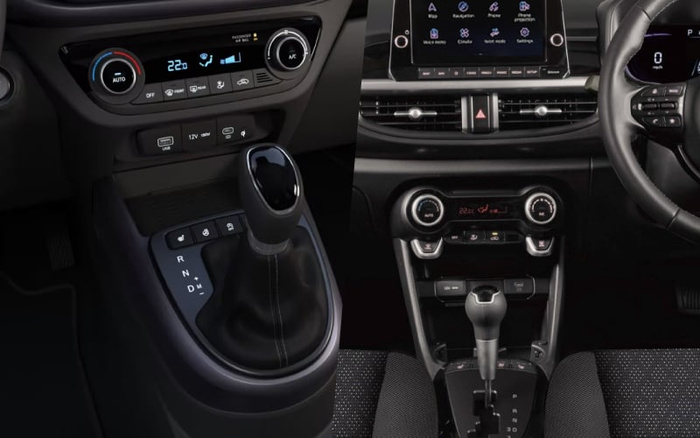 Close-up views of the central console area and gear shifters inside two cars, showing modern automatic transmission gear sticks with gear positions marked P, R, N, D, and M. The left image includes a climate control panel set to 22.0 degrees Celsius with buttons for AUTO mode, front and rear defrost, air conditioning, and air circulation. There are also USB and 12V power outlets below the controls. The right image displays the car's infotainment screen with icons for map, navigation, phone, projections, voice memo, climate, select model, and settings. The climate control panel below shows dual temperature dials set to 22.0 degrees Celsius. Both interiors have black seats with textured fabric and sleek, modern designs. Suitable for illustrating used cars and new cars with advanced interior features.