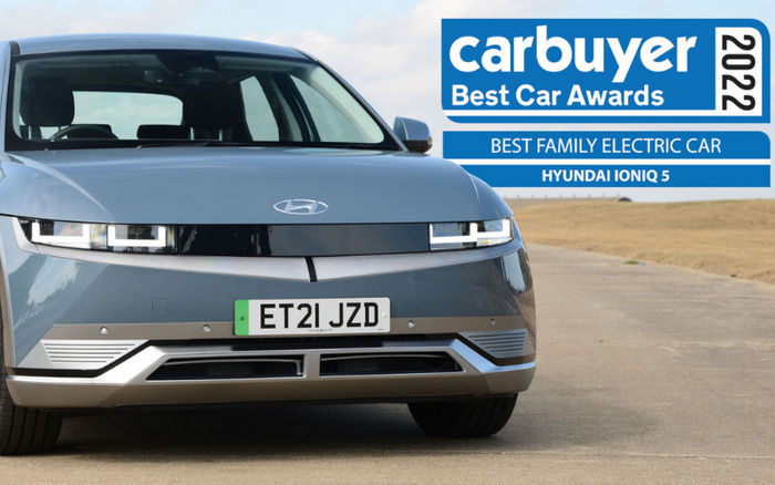Front view of a silver Hyundai Ioniq 5 electric car with licence plate ET21 JZD parked on a concrete surface with clear sky in the background. Blue and white banner in the top right corner reads 'carbuyer Best Car Awards 2022 Best Family Electric Car Hyundai Ioniq 5'. Emphasising used cars and new cars with award-winning electric family car.