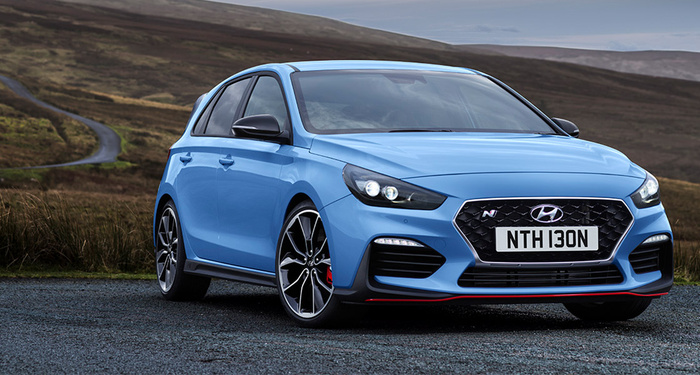 Blue Hyundai hatchback car with registration plate NTH 130N parked on a gravel road in a rural area with hills in the background, representing used cars and new cars for sale.