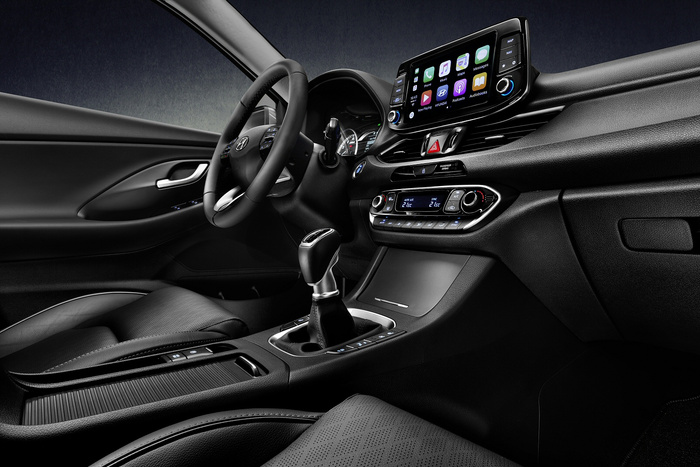 Interior of a modern Hyundai car showing the steering wheel with Hyundai logo, touchscreen display with app icons including Phone, Music, Maps, Messages, and Podcasts, digital climate control displaying 21.5°C, gear shift lever, and black leather seats and trim highlighting a sleek, contemporary design ideal for buyers interested in used cars or new cars.