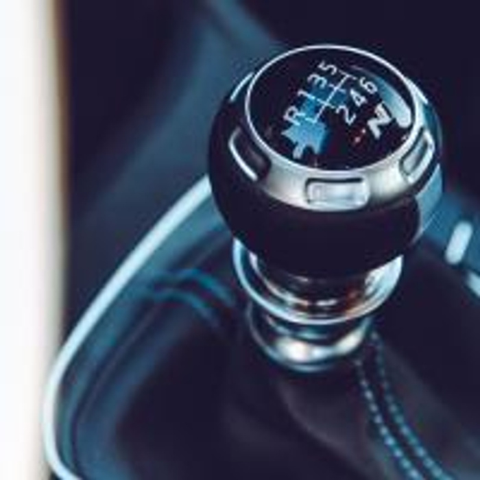 Close-up of a car's manual gear stick showing six-speed transmission with reverse, emphasising the interior detail of used cars and new cars.