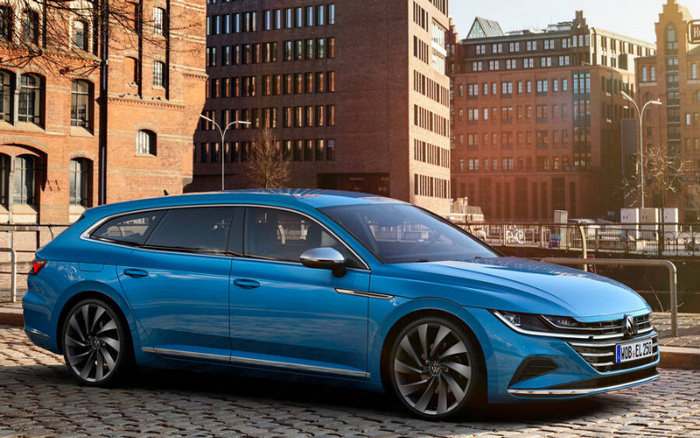 Blue Volkswagen Arteon shooting brake parked on cobblestone street with brick buildings in the background, featuring a German license plate WOB EL 250, highlighting sleek modern design of new cars and suitable for used cars market.