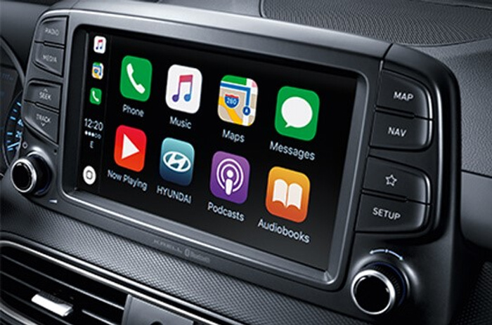 Car dashboard infotainment system displaying a touchscreen with app icons including Phone, Music, Maps, Messages, Now Playing, Hyundai, Podcasts, and Audiobooks, surrounded by physical buttons for Radio, Media, Seek, Track, Scan, Map, Nav, Star, and Setup, highlighting modern technology in used cars and new cars.