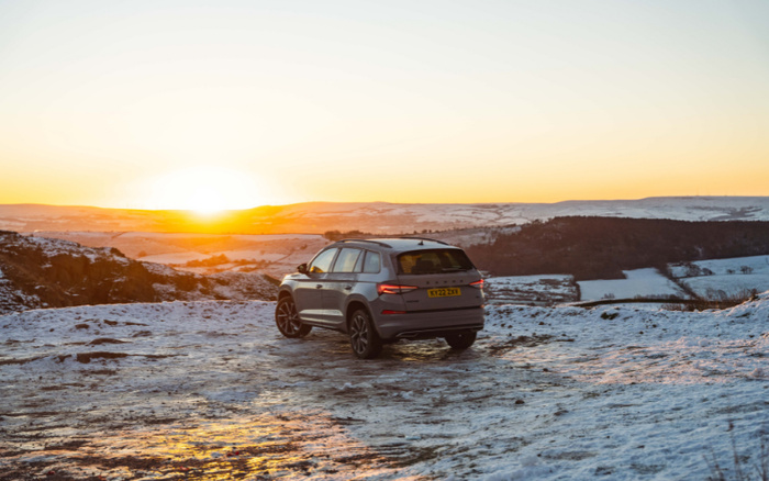 Silver SUV car with UK registration plate KY22 ZXJ parked on a snowy hill during sunset, overlooking a winter landscape with rolling hills and clear skies, suitable for promoting used cars and new cars in scenic outdoor settings.