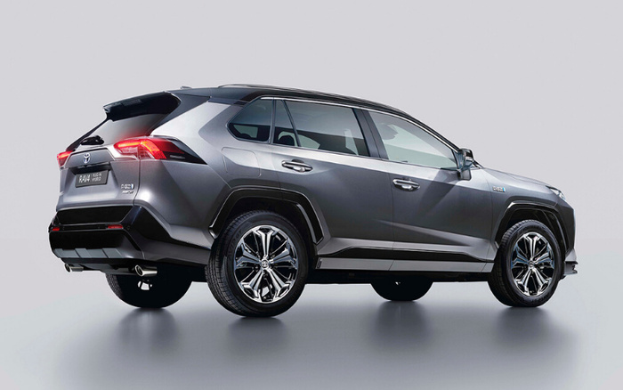 Grey Toyota RAV4 Hybrid SUV viewed from the rear side on a light grey background, showcasing its modern design, alloy wheels, and rear lights, ideal for promoting used cars and new cars.