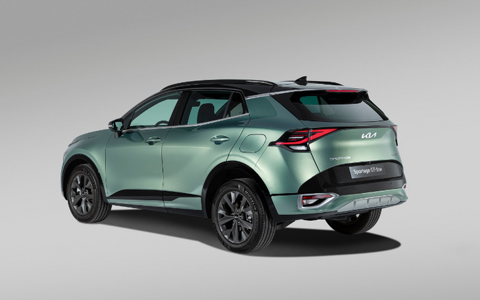 Rear side view of a green Kia Sportage 2.0 Turbo SUV car on a grey background, showcasing the sporty design and modern taillights. The car is a representation of new cars available, suitable for those interested in used cars or new cars.