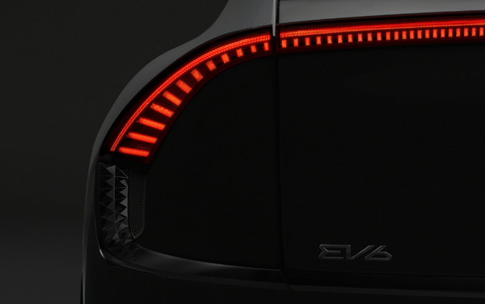 Close-up of a black car's rear showcasing a sleek red LED tail light design and the model badge reading EV6, highlighting modern design features relevant to both used cars and new cars markets.