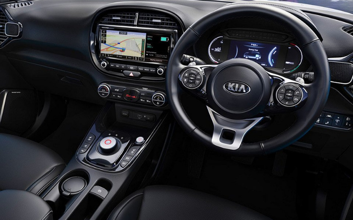 Interior of a Kia car featuring a black leather steering wheel with Kia logo, digital instrument cluster displaying a range of 362 km, infotainment screen showing a GPS navigation map and battery status at 80%, climate control settings with temperature set to 20.5°C, and a central console with gear selector dial and various control buttons, showcasing the modern dashboard design typical for used cars and new cars.