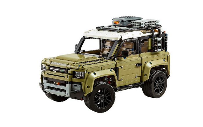 Detailed LEGO model of a Land Rover Defender in khaki green and white, showcasing intricate design elements including roof gear, front bumper, and black wheels, representing new cars and used cars for enthusiasts.