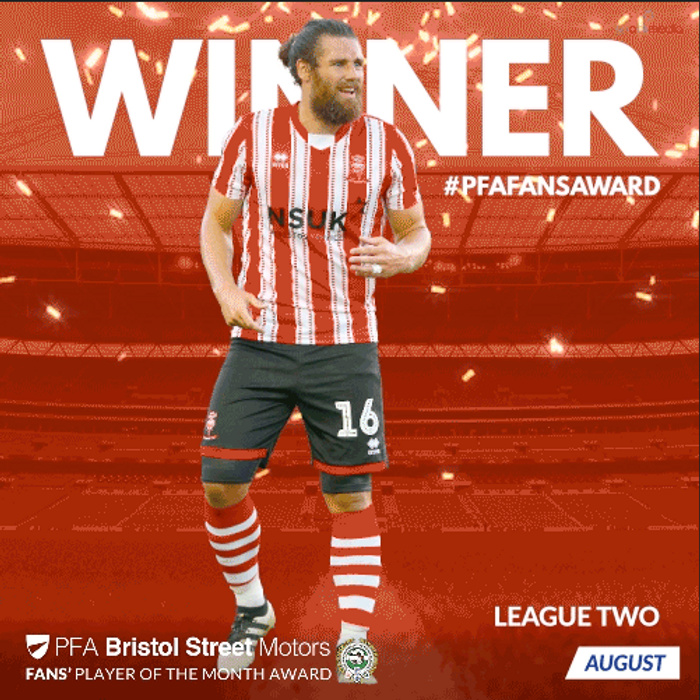 Professional football player in red and white striped kit with number 16, celebrating as winner of the PFA Fans' Player of the Month Award for League Two in August. Background features a stadium with bright lights and confetti, large text saying WINNER and hashtag #PFAFANSAWARD. Bristol Street Motors logo and text present, linking the award sponsorship to used cars and new cars dealership.