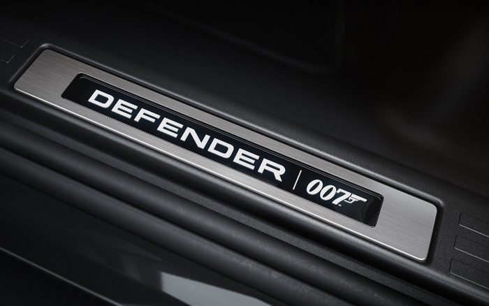 Close-up of a car door sill plate featuring the text 'DEFENDER' and the '007' logo with a gun symbol, highlighting a special edition or branding detail of this vehicle, relevant to used cars and new cars buyers interested in unique or branded models.