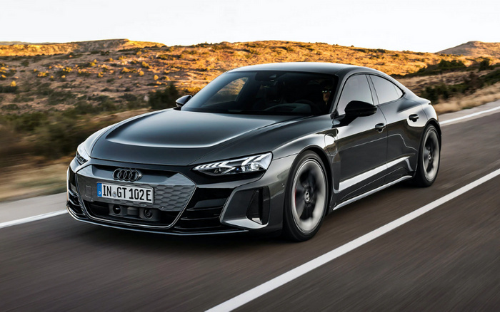 Black Audi electric car with licence plate IN GT 102 E driving on a desert road with rocky hills in the background, showcasing a sleek design suitable for buyers interested in used cars and new cars.