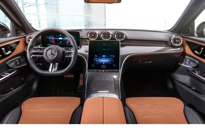Interior view of a luxury car showcasing the dashboard and front seats with brown and black leather upholstery. Features include a Mercedes-Benz steering wheel, digital instrument cluster, central touchscreen displaying navigation, climate control, and media options. Modern air vents and carbon fiber trim highlight the design, suitable for advertisements of used cars and new cars.