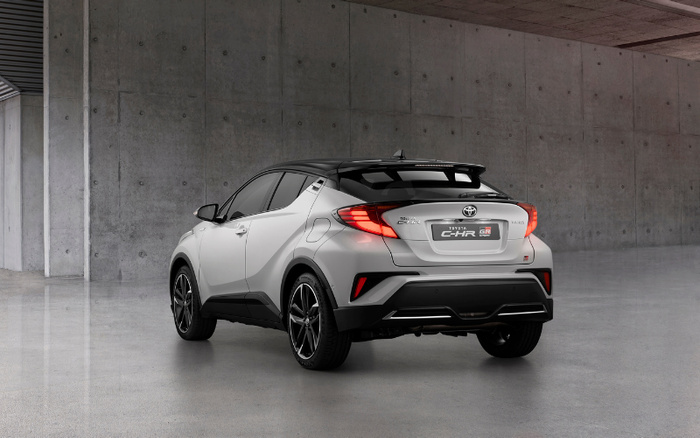 Silver Toyota C-HR GR Sport hatchback new car parked in a modern concrete indoor space, rear view highlighting stylish black roof, rear lights, and sporty design elements, showcasing a model that appeals to buyers interested in both used cars and new cars.