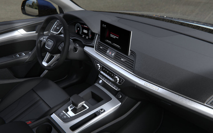 Interior view of a modern Audi car featuring a digital dashboard and central display screen showing a media player with the song 'Clair de Lune' paused. The dashboard has a sleek design with a 'quattro' badge on the passenger side trim, leather seats, and a centre console with gear selector and various control buttons. Suitable for showcasing used cars and new cars in premium condition.
