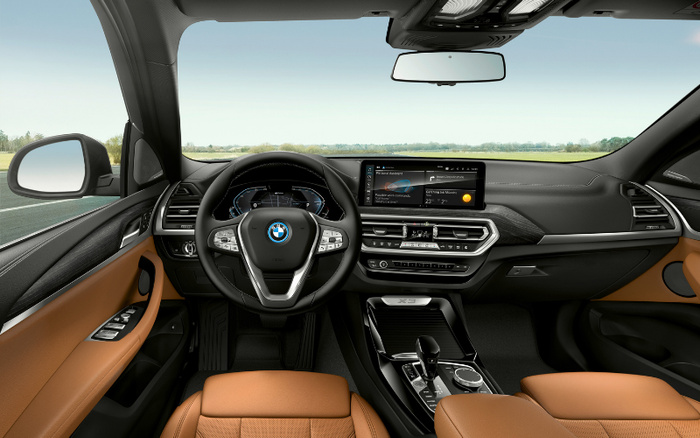 Interior view of a BMW car showcasing the steering wheel with BMW logo, a digital dashboard, a central touchscreen display showing navigation and weather information, and tan leather seats. The dashboard features climate control and multimedia buttons. This image highlights the modern, luxurious interior suitable for used cars and new cars buyers looking for advanced technology and comfort.