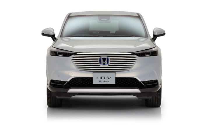 Front view of a white Honda HR-V e:HEV hybrid vehicle on a white background, showcasing the sleek grille and modern headlamp design, ideal for advertising used cars and new cars.