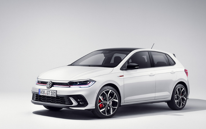 White Volkswagen Golf GTI hatchback car displayed in a studio setting with a clean white background, featuring sporty alloy wheels with red brake calipers and modern LED headlights. The car has a front license plate reading 'WOB GT 101'. Ideal image representing both used cars and new cars in the automotive market.