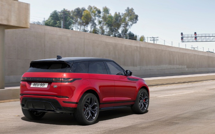 Red Range Rover SUV with black roof and wheels driving on a concrete road beside a beige sound barrier wall, showing rear and side view, featuring license plate REU 901, ideal for buyers looking for used cars or new cars.