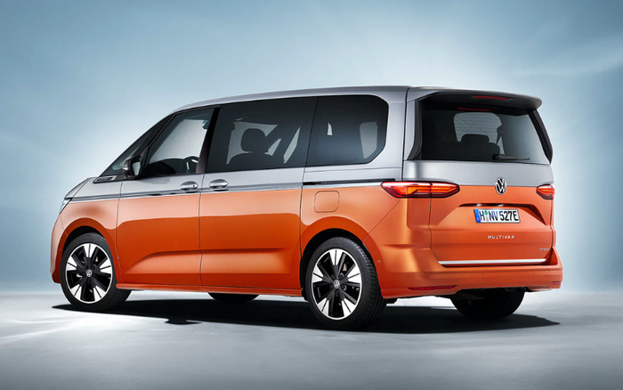 Side and rear view of a two-tone orange and silver Volkswagen Multivan with a German license plate reading 'H NW 527E', shown in a studio setting. The image highlights the sleek and modern design of this new car model, suitable for buyers interested in used cars or new cars.