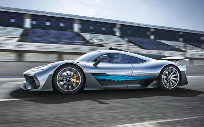 Silver and black high-performance Mercedes-Benz sports car racing on a track with blurred grandstands in the background, showcasing sleek aerodynamic design and blue graphics on the side, representing a luxury model in the new cars category, ideal for enthusiasts looking for high-speed vehicles similar to used cars or new cars in premium condition.