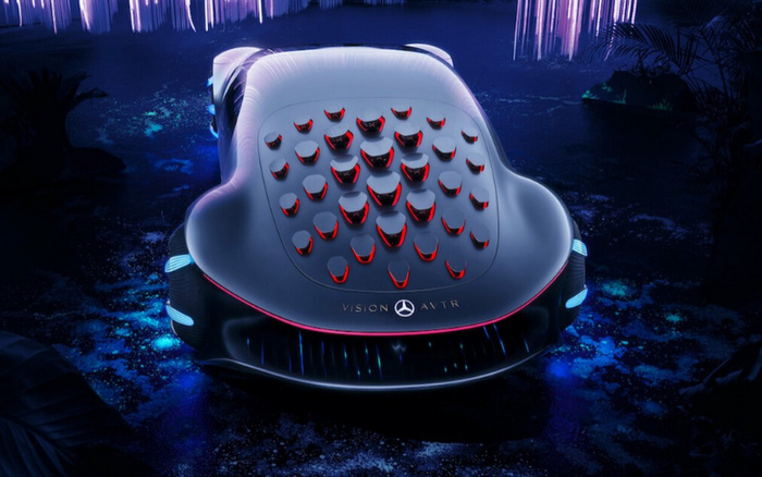 Rear view of the futuristic Mercedes-Benz Vision AVTR concept car illuminated in blue and purple lighting, showcasing its unique design with multiple red and black 3D shapes on the back, the Mercedes star logo, and 'VISION AVTR' text. This image highlights advanced automotive innovation relevant to discussions about new cars and used cars.